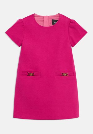 Lyserosa kortermet kjole med rund hals og to frontlommer med dekorative spenner i gullfarge.