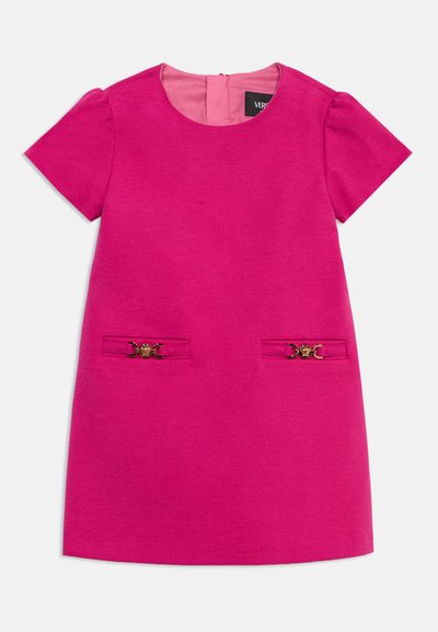 Φωτεινό ροζ φόρεμα με κοντά μανίκια, στρογγυλή λαιμόκοψη και δύο εμπρόσθιες τσέπες με διακοσμητικές πόρπες σε χρυσό τόνο.