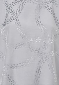 Tessuto trasparente con un ricamo intricato simile a catene d'argento su uno sfondo grigio chiaro, con una texture morbida e una leggera lucentezza.