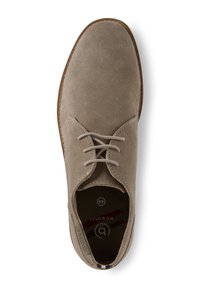 Chaussure en daim gris avec un bout arrondi, dotée d'un laçage et d'une semelle marron clair. À l'intérieur, le numéro de modèle et les détails de la marque sont visibles.
