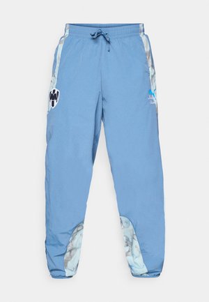 Svetlomodré športové nohavice s elastickým pásom, bočnými vreckami a abstraktnými vzormi na dolných stranách. Obsahujú detaily loga.