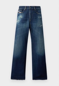 Brettjeans i mörkblått med blekta områden, slitna detaljer och fransade nederkanter. Fyrtio fickor och knäppning.