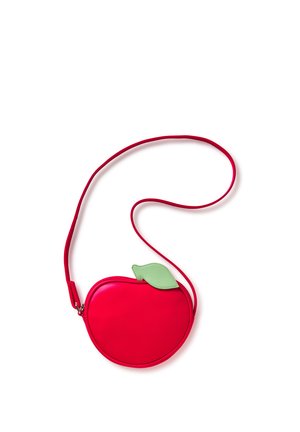 Sac bandoulière rouge en forme de pomme avec un accent de feuille verte et une longue sangle fine sur fond blanc.