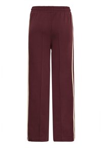 Pantaloni della tuta bordeaux con vita elastica, caratterizzati da due strisce cremisi verticali sui lati e un design a gamba larga. Texture morbida.