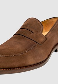 Braune Wildleder-Loafer mit abgerundetem Zehenbereich, lederner Innenausstattung, kontrastierendem Nähen und einem kleinen Absatz. Verfügt über ein kleines Lederstrappendetail.