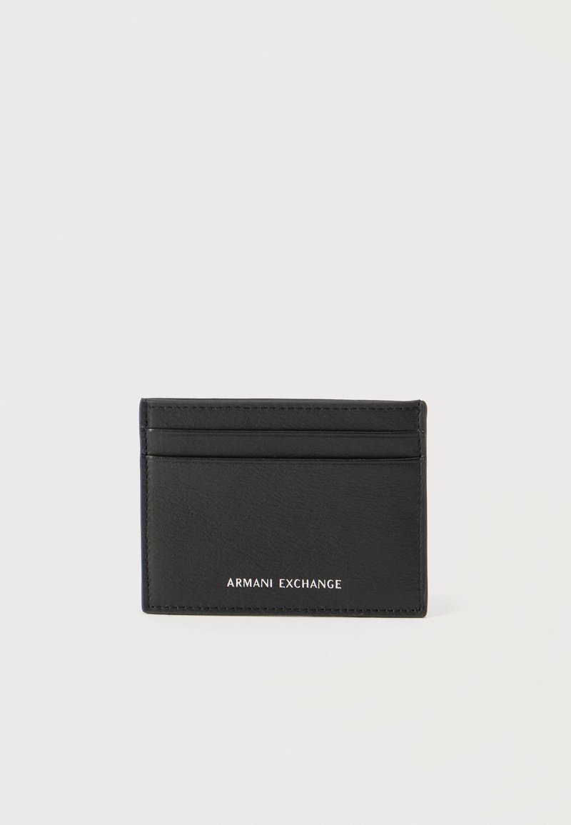 Μαύρη δερμάτινη θήκη καρτών με τρεις θήκες καρτών και το λογότυπο "ARMANI EXCHANGE" ανάγλυφο σε λευκό χρώμα στο μπροστινό μέρος, πάνω σε απλό φόντο.