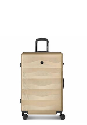 Valigia rigida beige con motivo ondulato, quattro ruote e manico telescopico nero esteso.
