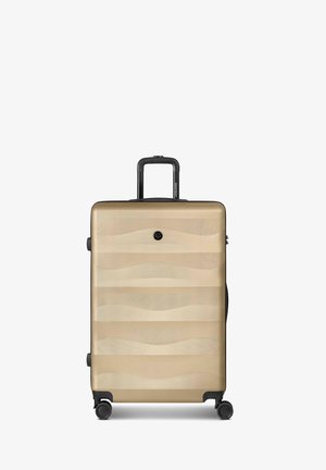 Hartschalenkoffer in Beige mit wellenförmigem Muster, vier Rollen und einem ausgezogenen schwarzen Teleskopgriff.