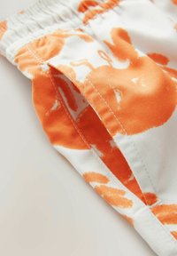 Orange blomsterprint stof med et afslappet fit-design, elastisk talje og pænt syede sømme. Blødt bomuldsmateriale.