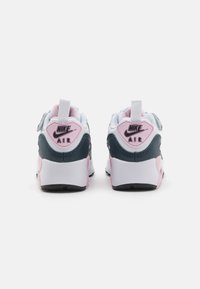 Tenisky Nike Air v bielej, ružovej a petrolejovej farebnej kombinácii, s hladkým koženým zvrškom a štruktúrovanými akcentmi na päte.