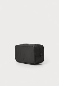 Borsa da toiletta rettangolare nera realizzata in tessuto resistente, dotata di chiusura con zip superiore e texture liscia, ideale per riporre durante i viaggi.