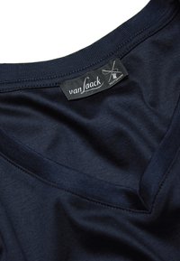 Himmelblaues V-Ausschnitt-T-Shirt mit weicher Textur. Verfügt über ein in Weiß gesticktes Etikett mit der Aufschrift "van Laack". Glattes Gewebe ohne auffällige Muster.