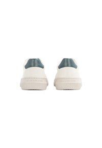 Zapatillas blancas con suela texturada y acentos en cuero verde en el talón. Presentan un logotipo en relieve en el talón y un diseño minimalista.