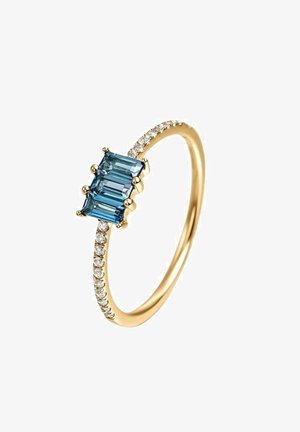 Anillo de oro con tres gemas azules rectangulares y una banda adornada con pequeñas piedras blancas, que presenta una superficie pulida y brillante.
