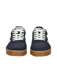 Sneaker blu navy con tomaia in tessuto testurizzato, lacci crema, suola in gomma naturale e cuciture tono su tono. Presenta un'etichetta con logo sulla linguetta.
