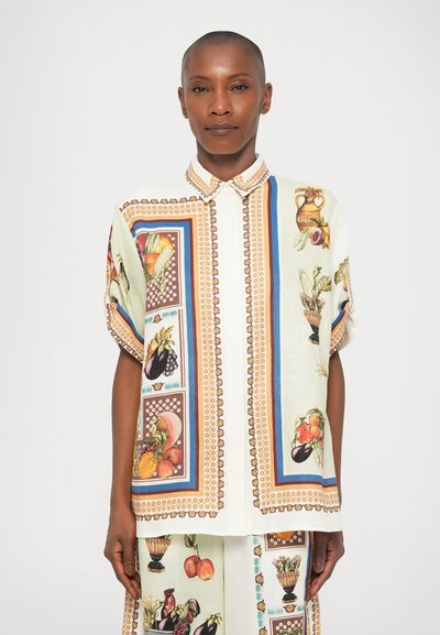 Short-sleeve shirt in light fabric, featuring colorful fruit and floral prints, with a structured collar and decorative trim along the edges.