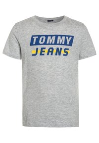 Camiseta de algodón gris con texto en azul y amarillo que dice "TOMMY JEANS". Diseño clásico de cuello redondo con mangas cortas.