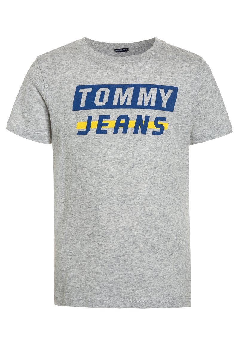 Camiseta de algodón gris con texto en azul y amarillo que dice "TOMMY JEANS". Diseño clásico de cuello redondo con mangas cortas.