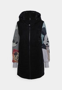 Chaleco acolchado negro con capucha, que presenta mangas grises con estampado. El diseño incluye gráficos de dibujos animados y texturas contrastantes.