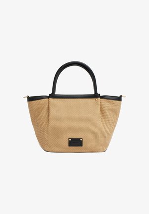 Bolso tote tejido beige con asas de cuero negro, ribete y una etiqueta negra rectangular en el centro delantero sobre un fondo blanco.