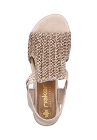 Sandale beige avec un dessus tissé, bout ouvert et sangles à la cheville. Présente une semelle intérieure rembourrée et une semelle plate pour le confort. Détail du logo doré.