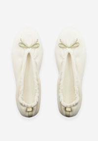 Chaussons de couleur crème en tissu doux avec une ouverture élastique froncée et des nœuds décoratifs vert clair à l'avant.