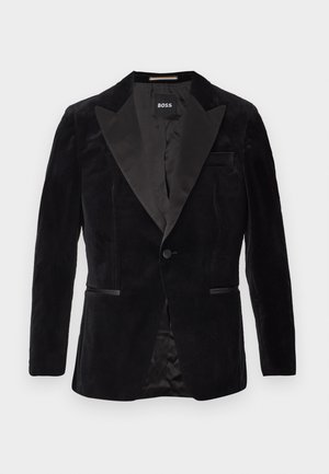 Black velvet blazer with satin lapels, single button closure, side pockets, and smooth interior lining. Label visible inside.