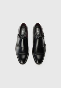 Schwarze Lederschuhe mit glatter Oberfläche, ausgestattet mit einem Doppelschnallen-Design und spitzen Zehen, gefüttert mit Burgunderrot.