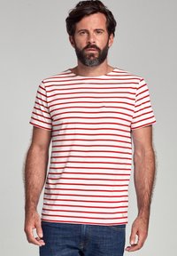 Rood-wit gestreept T-shirt, ronde hals, korte mouwen, gemaakt van katoen. Heeft een klein logo accent nabij de zoom.