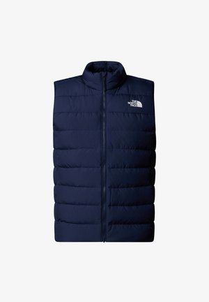 Donkerblauwe puffer vest met een hoge kraag, voorzien van een rits aan de voorkant en horizontaal doorgestikt ontwerp. Logo weergegeven aan de bovenlinkerzijde.