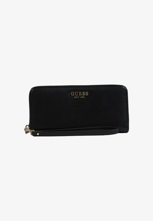 Black leather wallet with a zip closure, gold "GUESS" logo on the front, and a wrist strap. Smooth texture and rectangular shape.