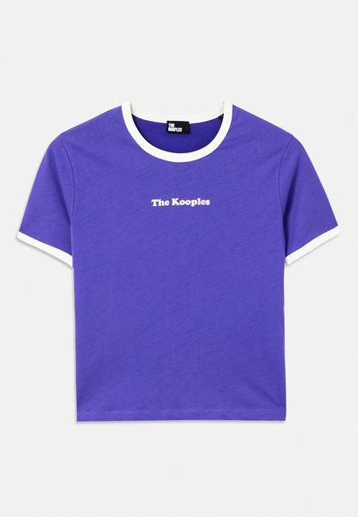 Violeta kokvilnas T-krekls ar baltu ribotu apkakli un piedurkņu malu, uz kura priekšpuses ir izdrukāts "The Kooples" logo baltā krāsā.