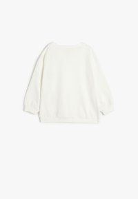 Sudadera de algodón blanca con cuello redondo, mangas largas y puños acanalados. Textura suave, sin patrones visibles ni acentos.