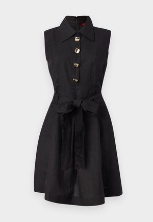 Μαύρο αμάνικο φόρεμα με φαρδιά γιακά, χρυσά τετράγωνα κουμπιά μπροστά και υφασμάτινη ζώνη δεμένη φιόγκος στη μέση.