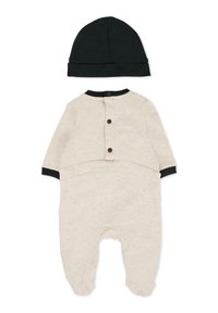 Bodysuit pour bébé couleur crème avec des manches longues, bord noir, fermeture à boutons à l'arrière, et un bonnet noir assorti en tissu doux.