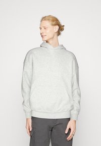 Hanorac gri din material moale, cu buzunar tip kangur, mansete cu elastic și glugă cu șnur. Design casual, cu o croială relaxată.