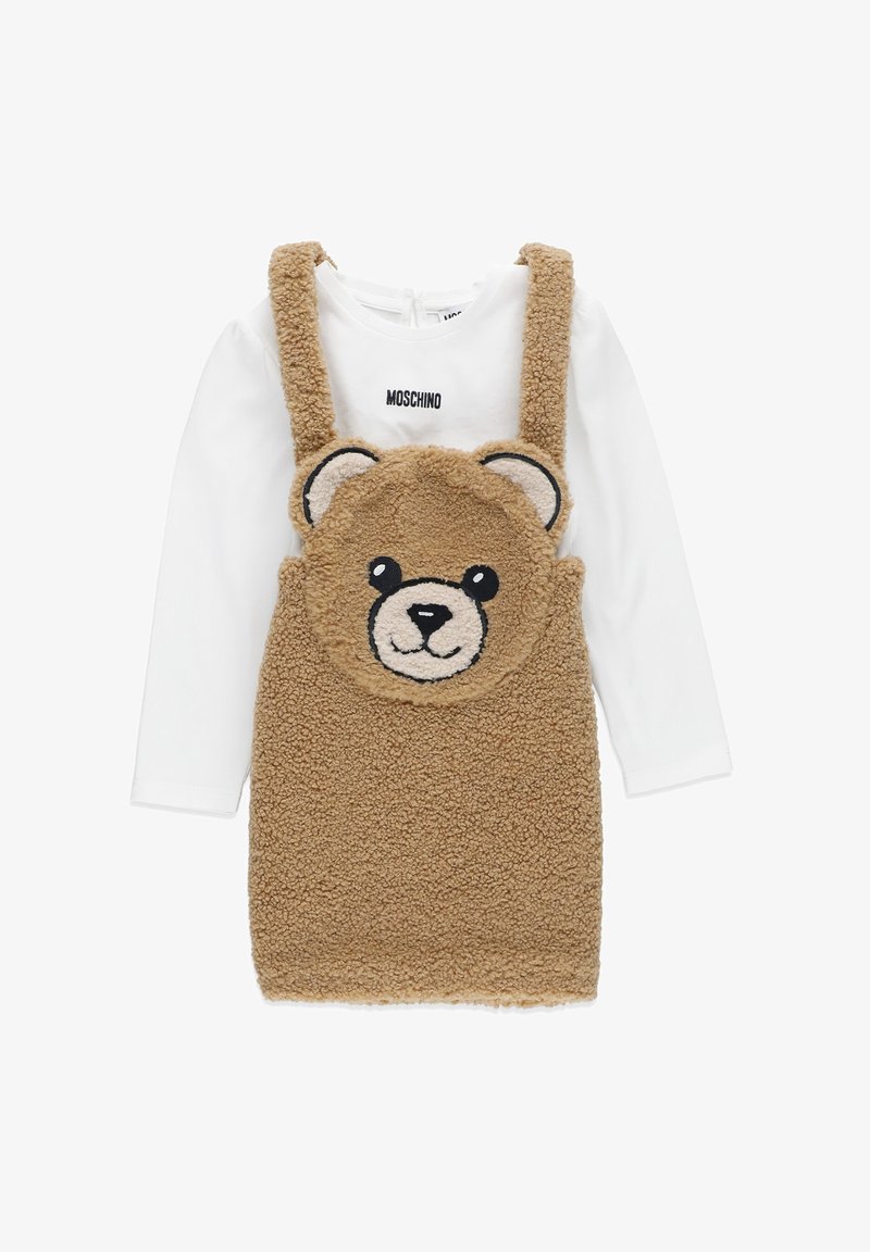 Abito in felpa marrone con design di faccia d'orso. Camicia interna a maniche lunghe bianca con logo "Moschino". Accenti a forma d'orso sulle spalline. Texture morbida.