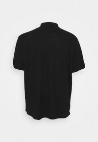 Polo a maniche corte nera con colletto classico, caratterizzato da una texture liscia e orlo posteriore dritto, progettato per una vestibilità rilassata.
