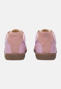 Sneaker in pelle e suede rosa con suola in gomma marrone testurizzata. Forma arrotondata, dettaglio di cucitura sul retro e una morbida fodera interna.