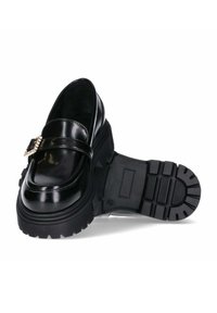 Zwarte gepatineerde leren instappers met een stevige rubberen zool, voorzien van een decoratieve metalen accent op de band en een gladde, glanzende afwerking.