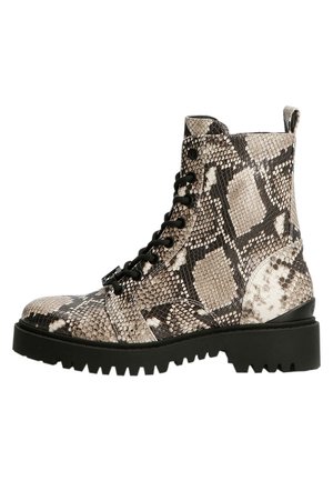 Botte montante à lacets avec semelle noire et texture beige à motif peau de serpent marron.
