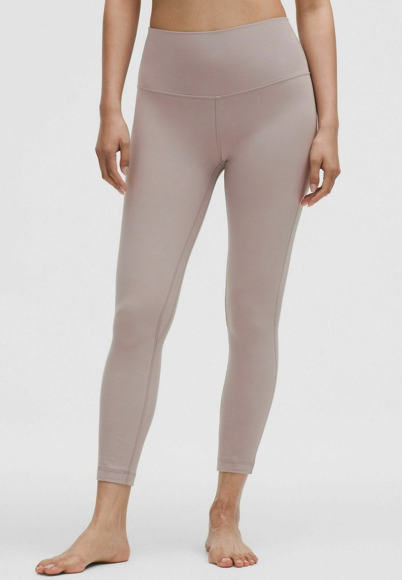 Jasnoróżowe legginsy z wysokim stanem, wykonane z elastycznego, gładkiego materiału. Charakteryzują się dopasowanym krojem z bocznymi szwami i długością do kostek.
