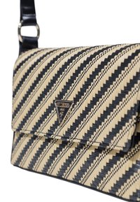 Sac à épaule tissé noir et crème avec un motif rayé, un logo triangulaire, et une bandoulière noire lisse avec des accents métalliques.