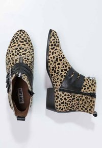 Leopard print ankle boots featuring a textured tan outer, black leather accents, zip closures, and a low stacked heel.
