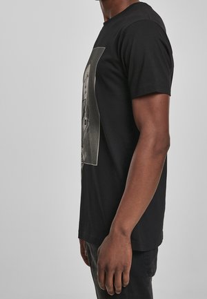 T-shirt en coton noir avec un imprimé graphique frontal, col rond, manches courtes et ourlet droit.