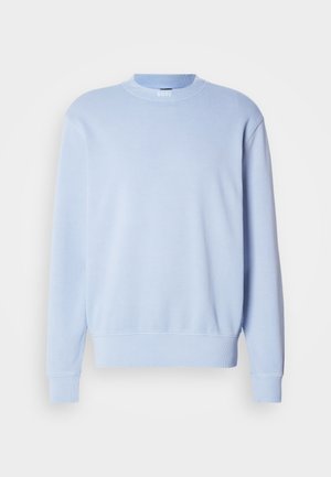 Světle modrý svetr vyrobený z měkké směsi bavlny. Má kulatý výstřih, ribbed manžety a lem, s jemným logem na výstřihu.