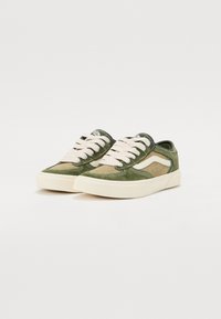 Grønne sued sneakers med beige accenter, som har tykke cremelænder og en rund tå, samt en hævet gummisål for bedre greb.