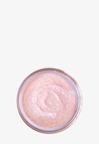 Scrub zuccherino rosa in un barattolo rotondo trasparente. Texture liscia e cremosa con una leggera lucentezza. Confezione semplice senza ulteriori accenti o motivi.