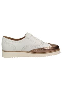 Chaussure brogue en cuir blanc avec embout métallique bronze, détails perforés, lacets blancs et semelle épaisse en caoutchouc blanc.