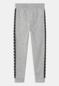 Grå sweatpants i mjukt material, med svarta sidostråk som har ett upprepat logomönster och en elastisk midjever.